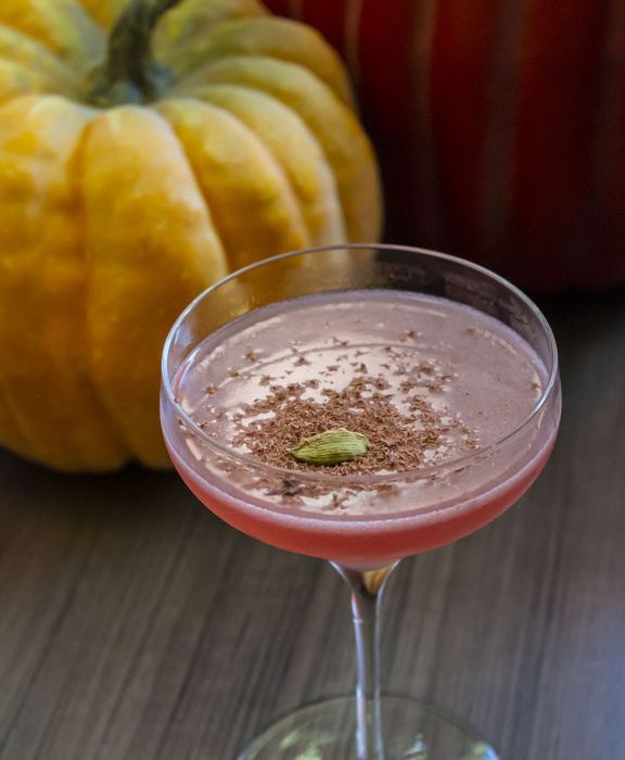 An autumn cocktail beside a pumpkin