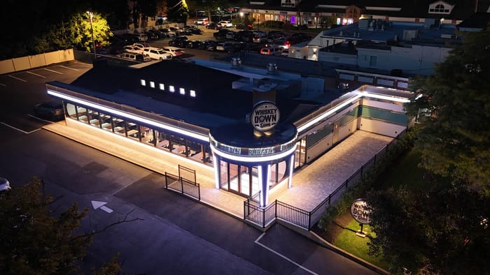 The Babylon Village building lit up at night, seen from above