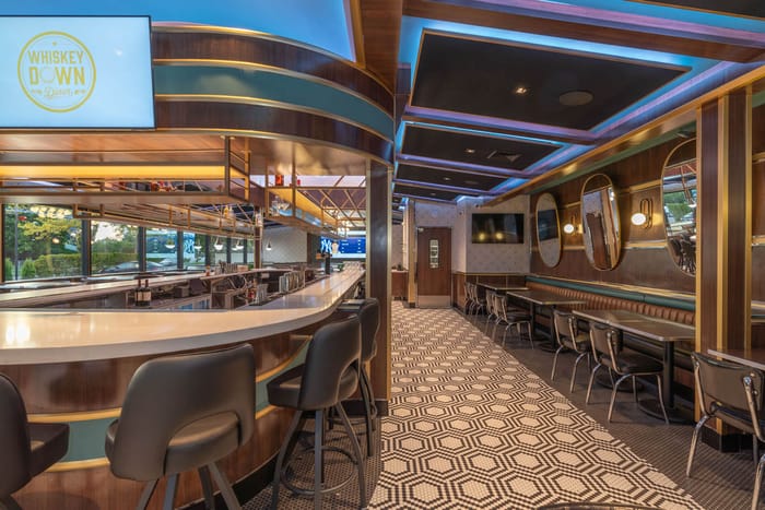 The bar and banquette seating in Babylon Village, with oval mirrors