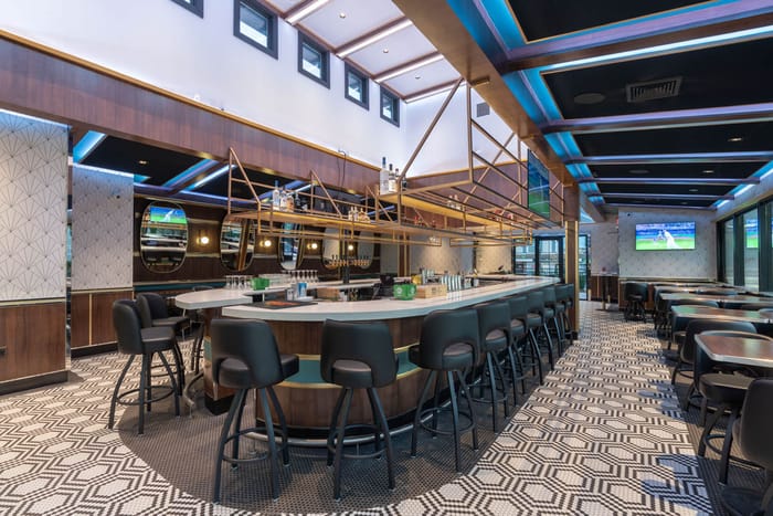 The long bar in Babylon Village, lit from the clerestory windows above