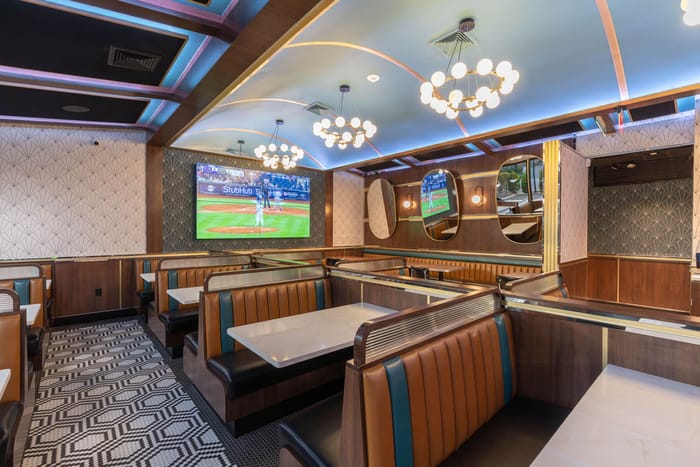 Booth seating under globe chandeliers in Babylon Village
