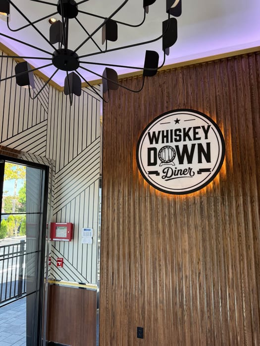 The backlit Whiskey Down Diner logo inside the Babylon Village entrance
