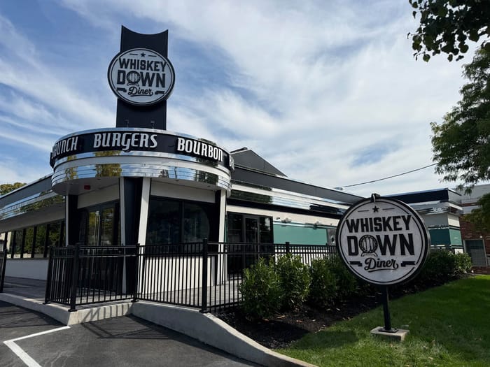 The Babylon Village storefront and sign in daylight