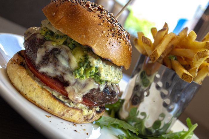 Burger on a sesame pretzel bun with waffle fries