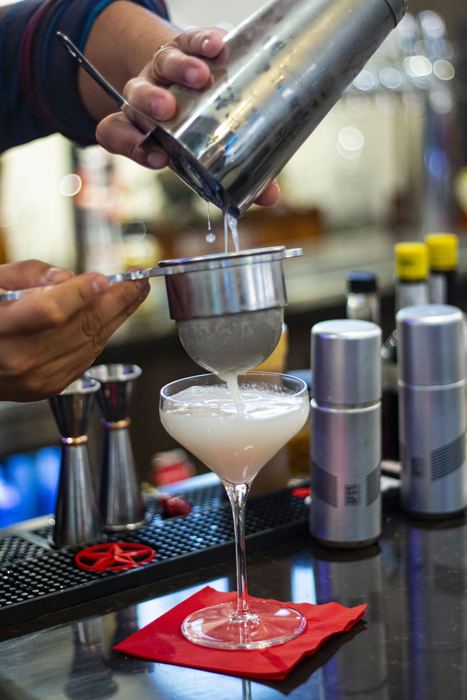 Straining a cocktail into a coupe