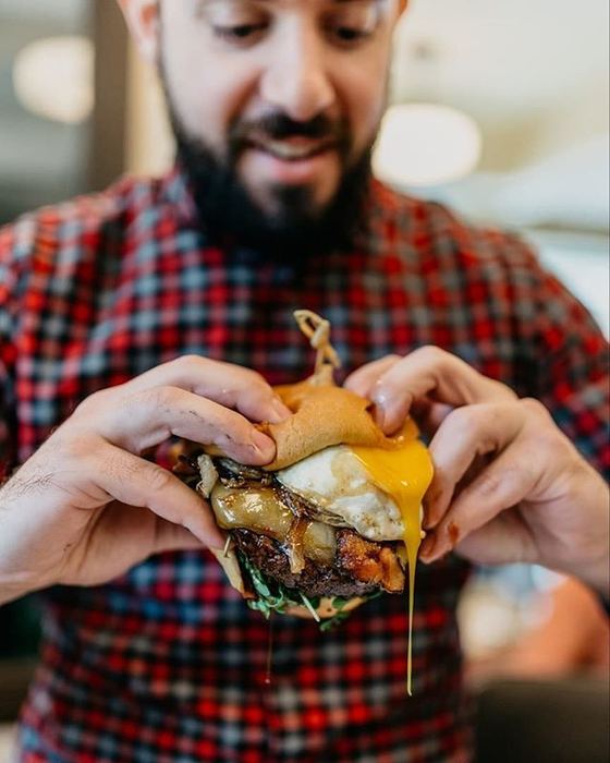 A guest with a burger at the counter