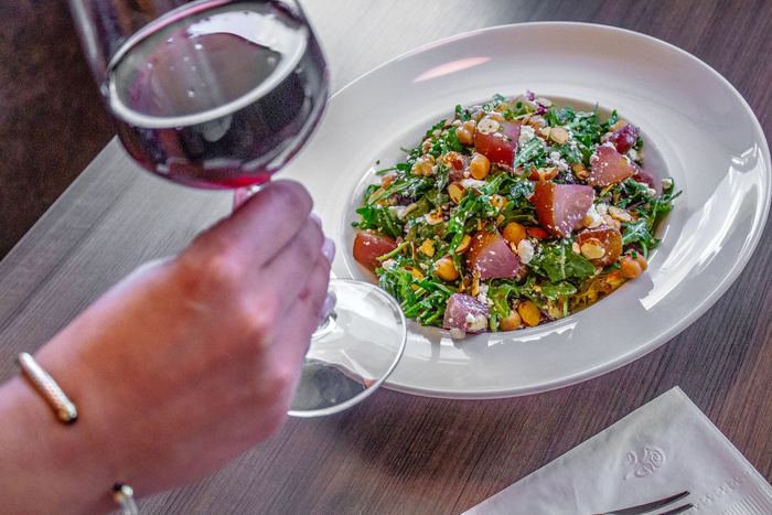 A chopped salad with a glass of red