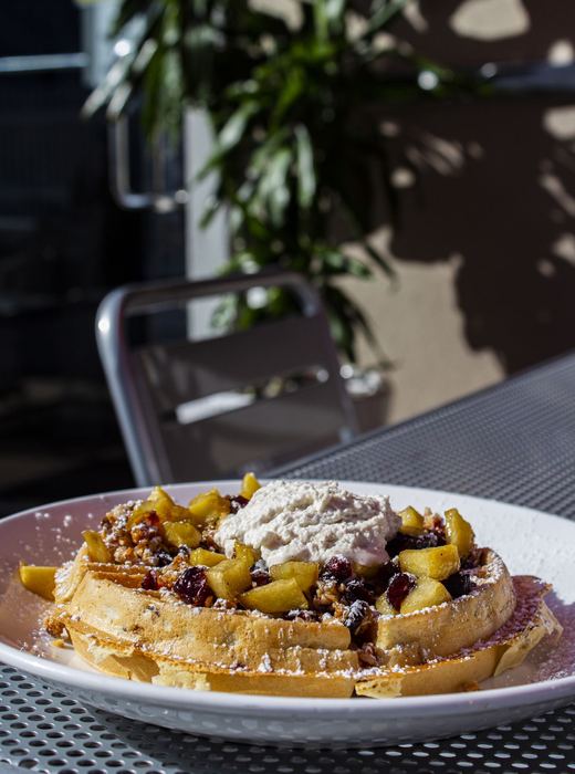 Waffle topped with fruit and whipped cream