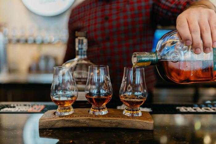 A whiskey flight poured on a board